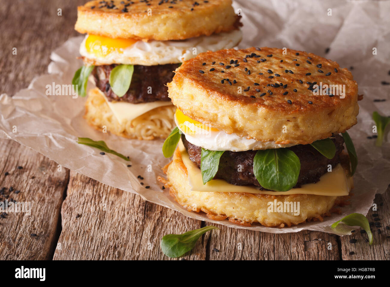 Neue Fast-Food: Ramen Burger Nahaufnahme auf ein Papier auf dem Holztisch. horizontale Stockfoto