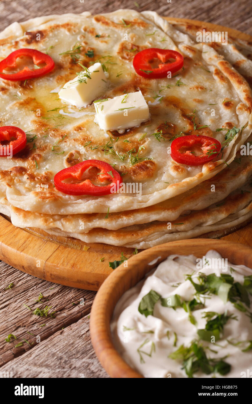 Indisches Essen: heiße Paratha mit Butter Nahaufnahme auf dem Tisch. vertikale Stockfoto