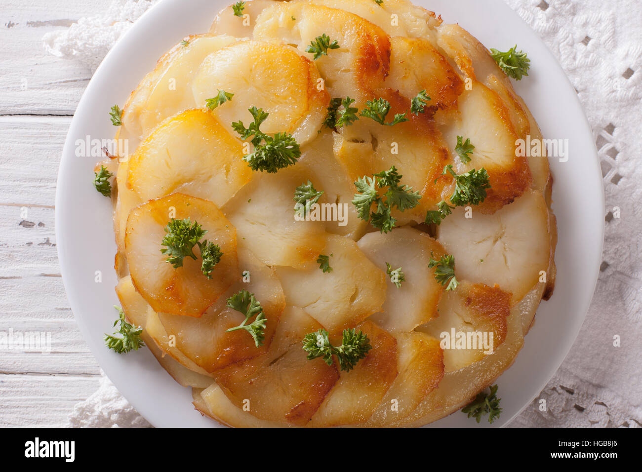 Französisches Essen: Kartoffel-Gratin auf weißen Teller Closeup auf dem Tisch. vertikale Ansicht von oben Stockfoto
