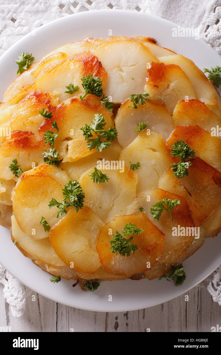 Französisches Essen: Kartoffel-Gratin auf weißen Teller Closeup auf dem Tisch. vertikale Ansicht von oben Stockfoto