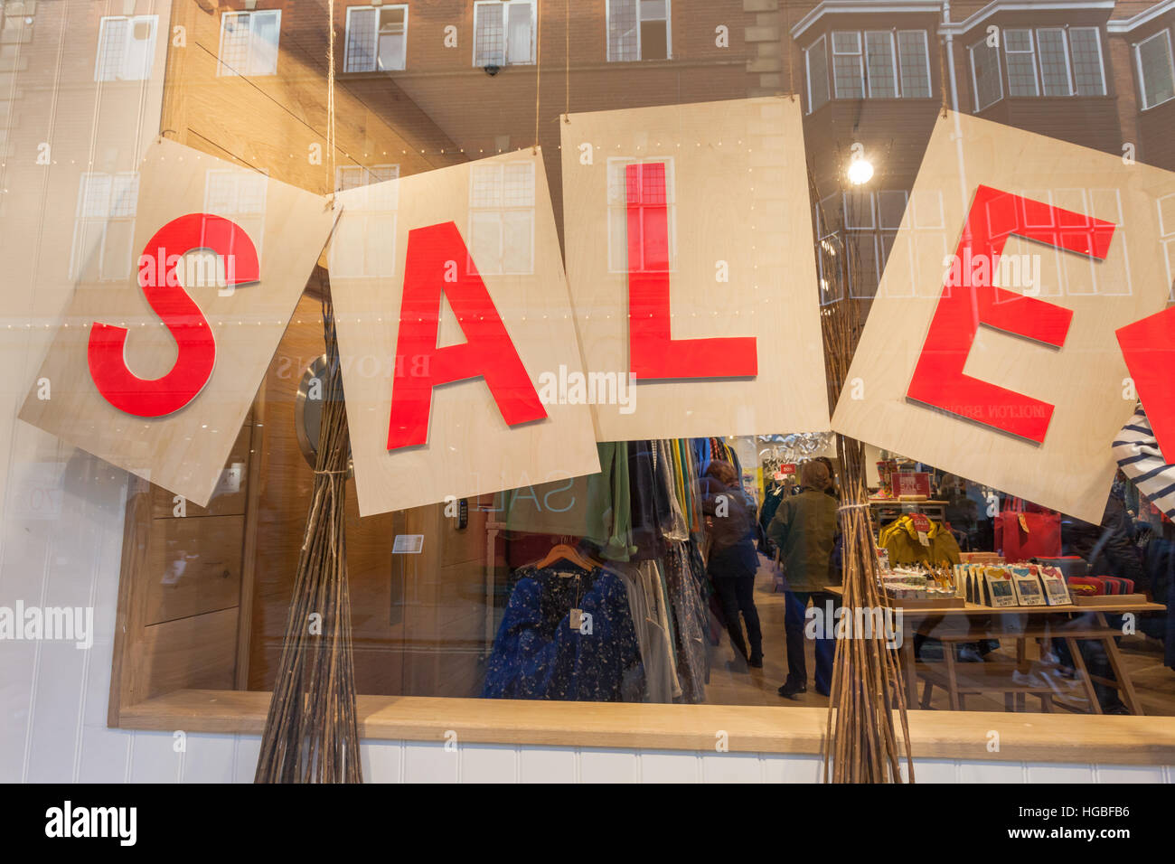 Verkaufsschild im Schaufenster, auf vier einzelne Blätter oder Bretter, während der traditionelle Januar-Umsatz in Geschäften in Großbritannien abgebildet. Stockfoto