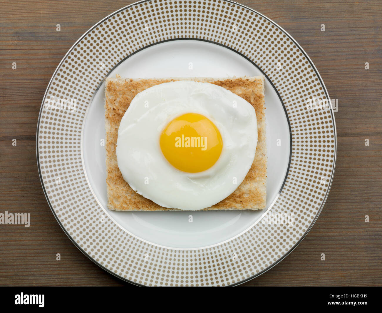 Ein frisch zubereitetes Frühstück von einem Spiegelei auf Toast oder leichtes Mittagessen Sunny Side Up serviert auf einem Teller mit keine Menschen als Flach Zusammensetzung Stockfoto