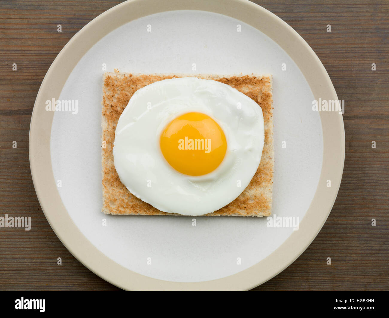 Ein frisch zubereitetes Frühstück von einem Spiegelei auf Toast oder leichtes Mittagessen Sunny Side Up serviert auf einem Teller mit keine Menschen als Flach Zusammensetzung Stockfoto