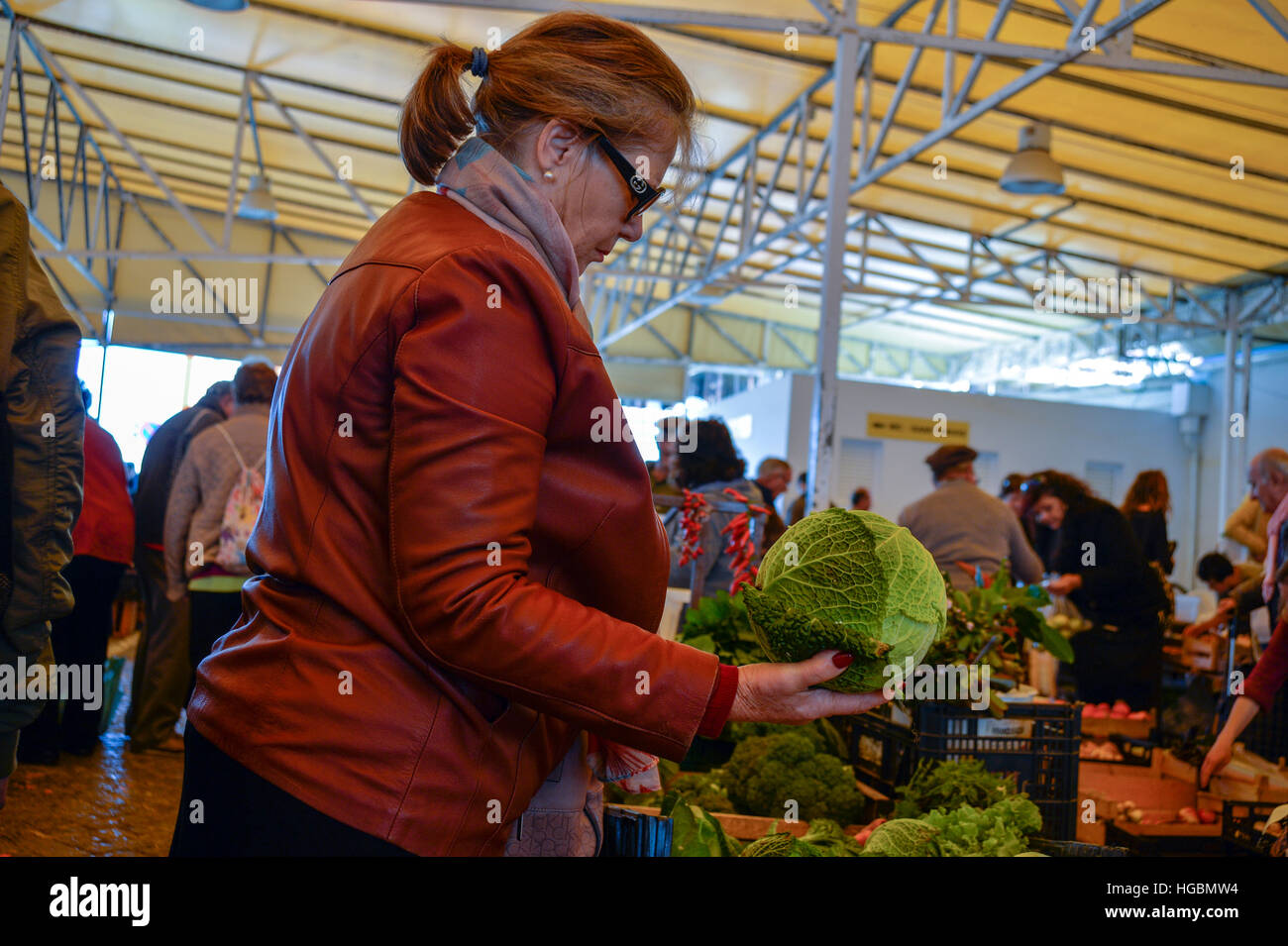 Frau, die Inspektion eines Kohlkopf auf einem Bauernmarkt Stockfoto