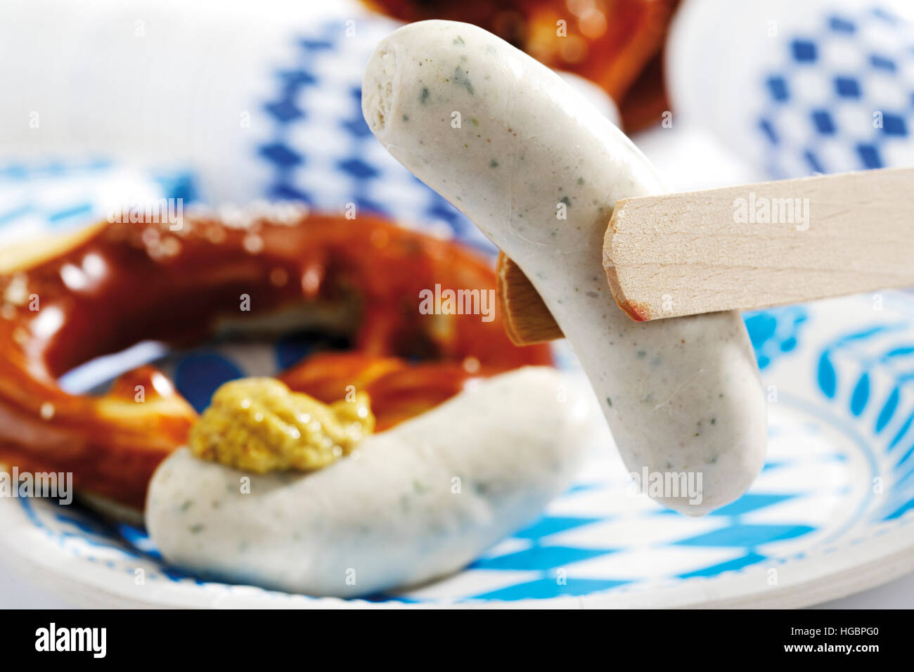 (Bayerisches) Weißwürste auf hölzernen Zange hinter servierten Teller ... (Bayerisches) Weißwürste auf hölzernen Zange hinter servierten Teller ...