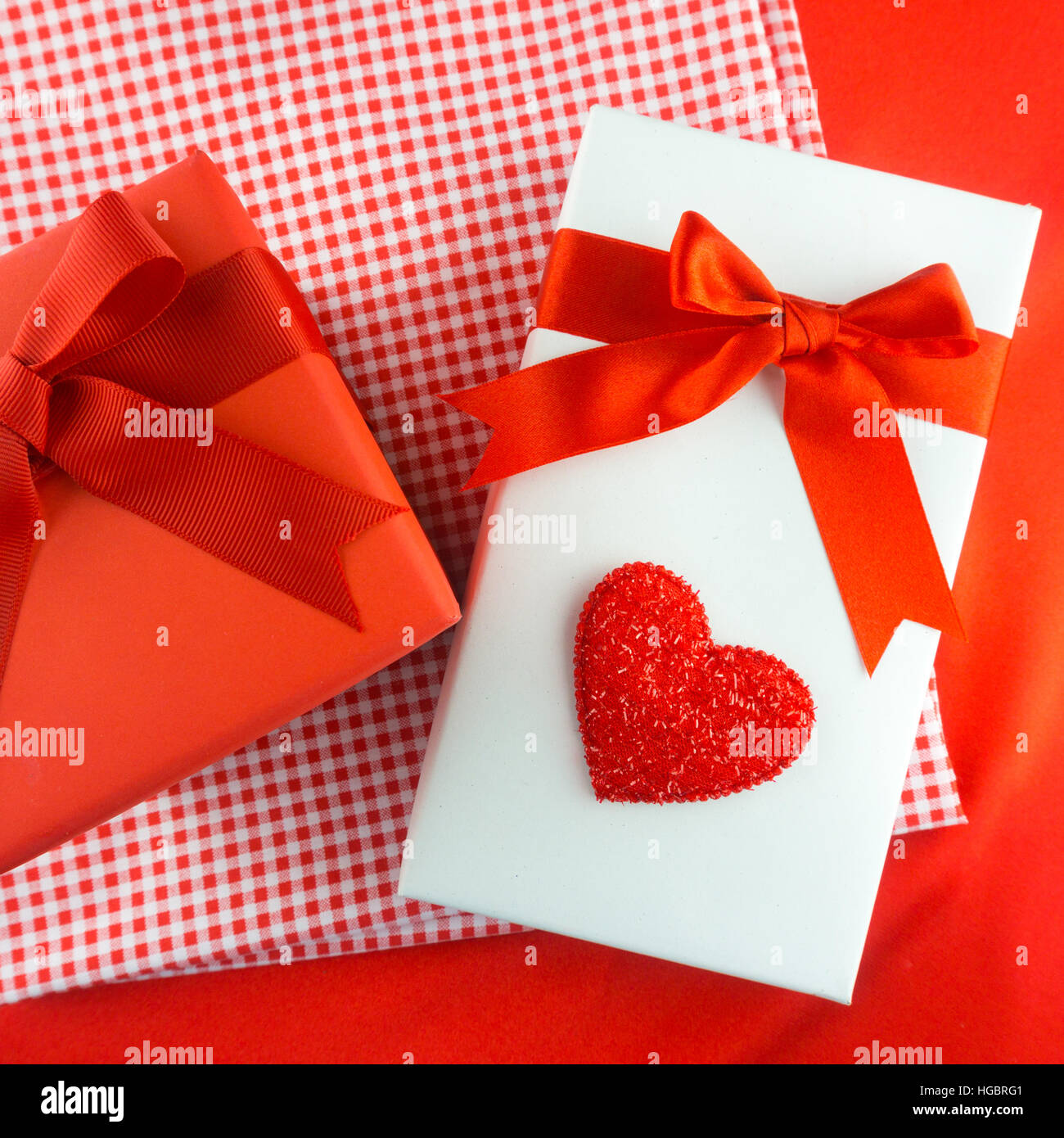 Valentines Geschenk-Box mit einer roten Schleife auf rotem Grund. Bild der Valentinstag. Stockfoto