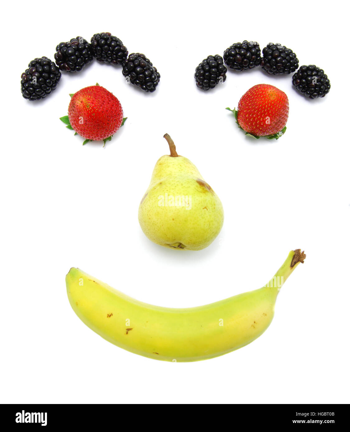 Happy Smiley Früchte. Kinderfreundlich. Essen Sie Ihre Früchte. Banane, Birne, Erdbeere und Brombeere. Stockfoto