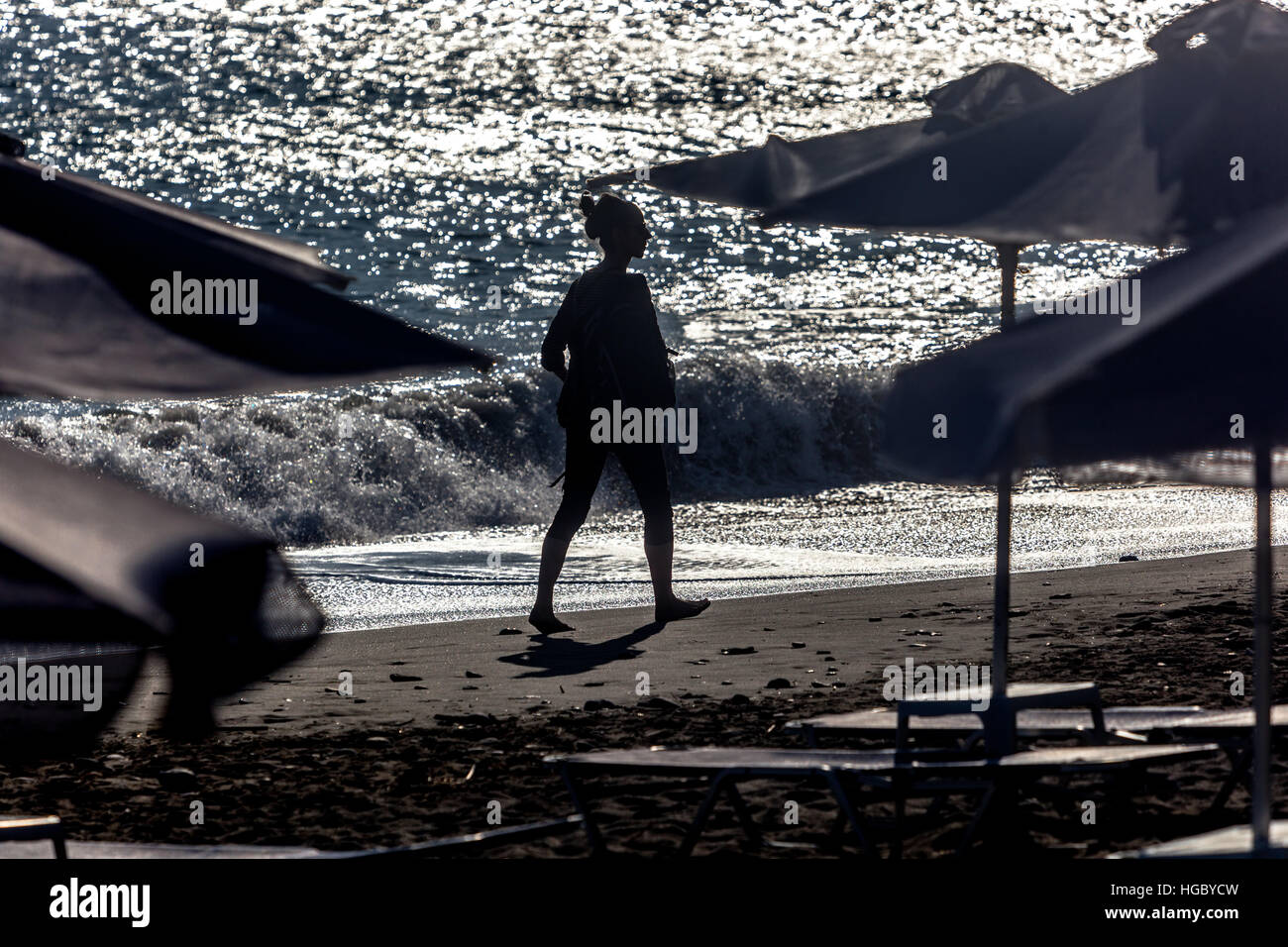 Silhouette einer Frau, die am Strand entlang geht, Plakias, Kreta, Griechenland Schatten Stockfoto