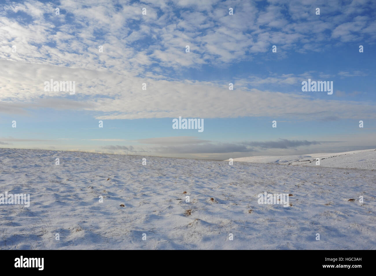 Blauer Himmel Cumuluswolken anzeigen Schnee auf sanften Abhang des Oldgate Mooses, Blick nach Westen von Pennine Way, südlich der A640 Huddersfield Road, South Pennines, UK Stockfoto