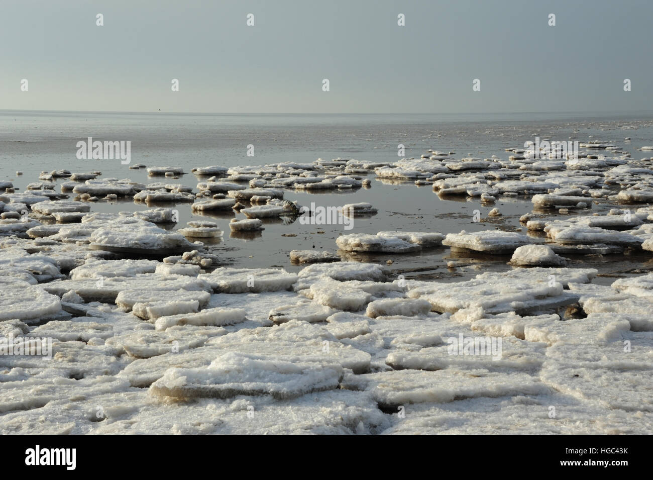 Blau-grauen Himmel, sonnigen Tag Ansicht unebenem Land-schnell-See Eisblöcke, Marge ruhigem Meerwasser, Strand östlich von St. Annes, Lancashire, UK Stockfoto