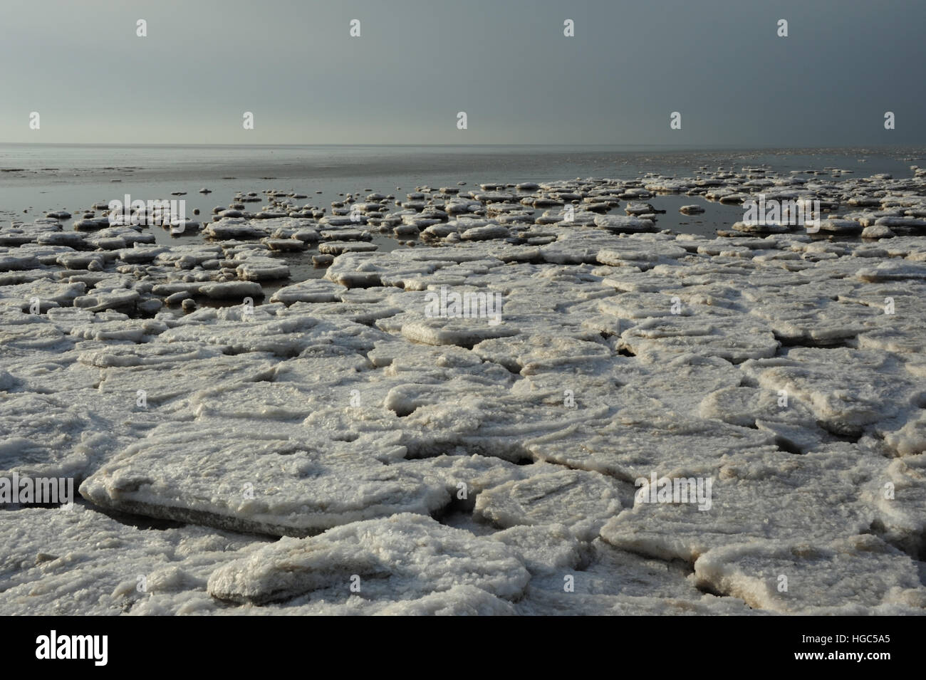 Grauen Himmel Ansicht große weite Land Fast Meer Eisblöcke am Rande des ruhigen Meer, Strand östlich von St. Annes, Blick nach Westen, Lancashire, Stockfoto