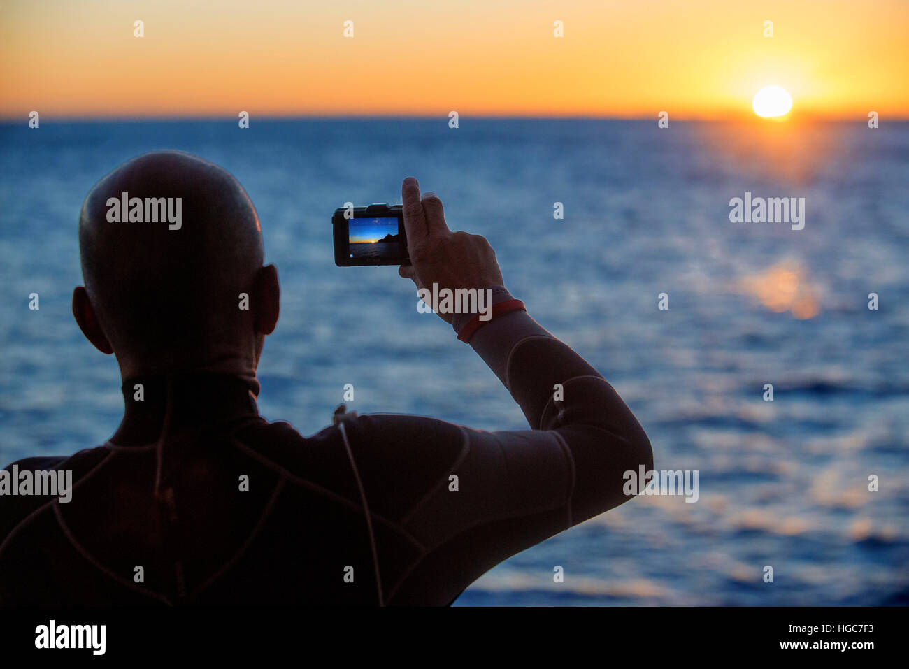 Ein Tourist Fotografieren bei Sonnenaufgang in Los Islotes Seelöwen Rookery, Sea of Cortez, Baja California, Mexiko. Kalifornische Seelöwen Zalophus californianu Stockfoto