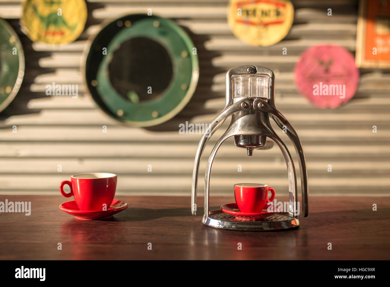 Manuelle Oldschool Espresso Maker Maschine mit einer Tasse auf Holztisch im schönen Morgenlicht Stockfoto