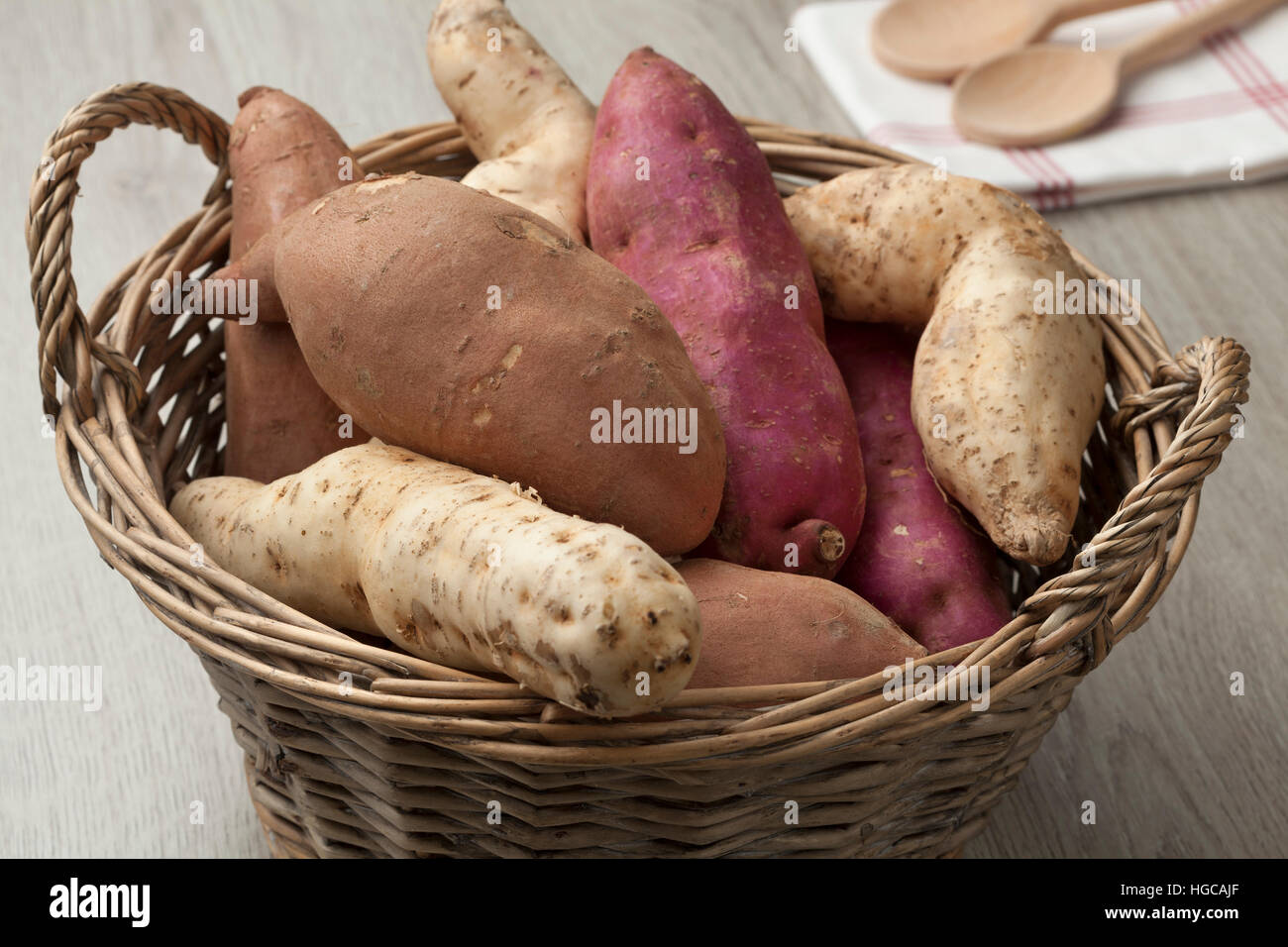 Korb mit weiß, rot und lila Süßkartoffeln Stockfoto