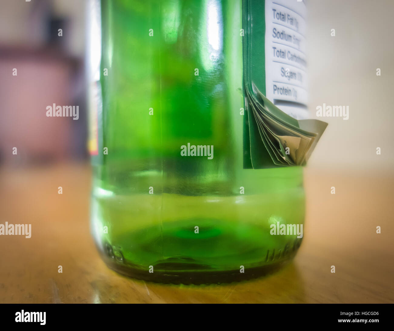 Eine Glasflasche mit vielen Etiketten übereinander, zeigt eine Störung an der Produktionsstätte. Stockfoto