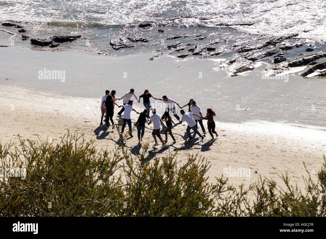 Gesichtslosen Menschen Hand in Hand und läuft in einem Kreis am Strand Spaß haben. Stockfoto