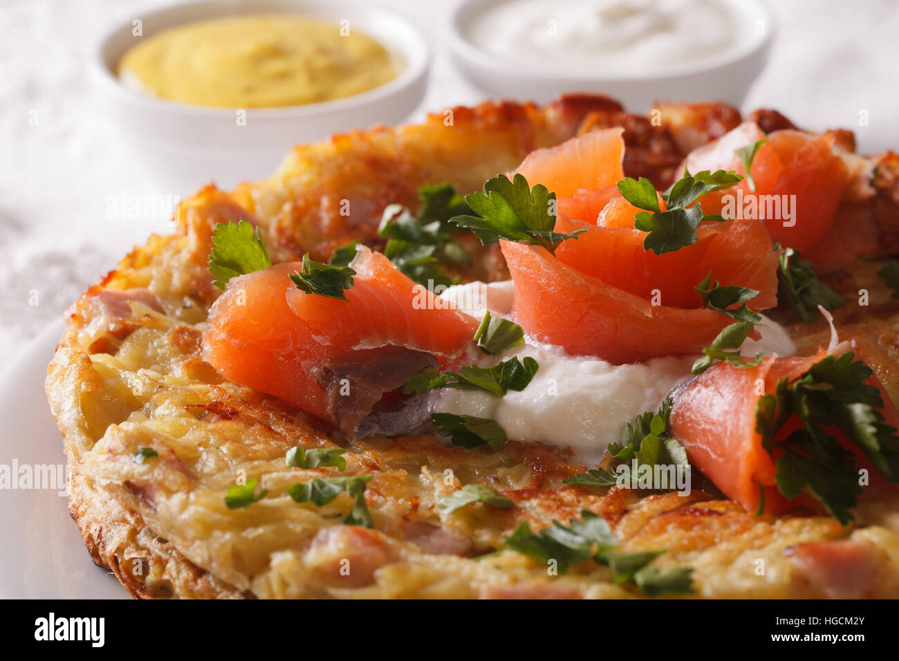 Schweizer Küche: Reibekuchen mit geräuchertem Lachs Makro auf einem Teller. Horizontale Stockfoto