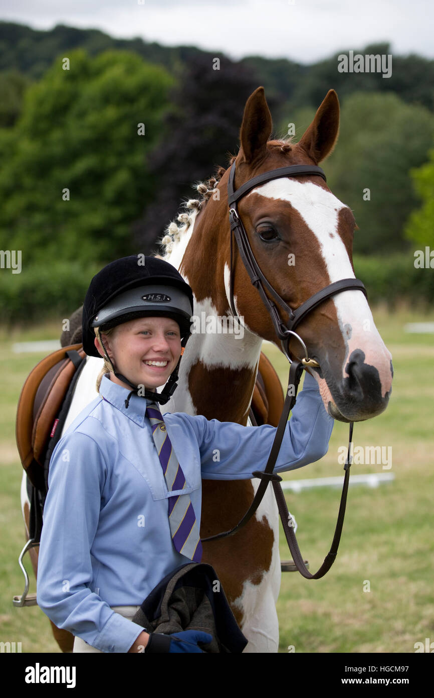 Portrait der junge lächelnde Jugendmädchen Pony Club rider ständigen Holding skewbald Horse uk Stockfoto