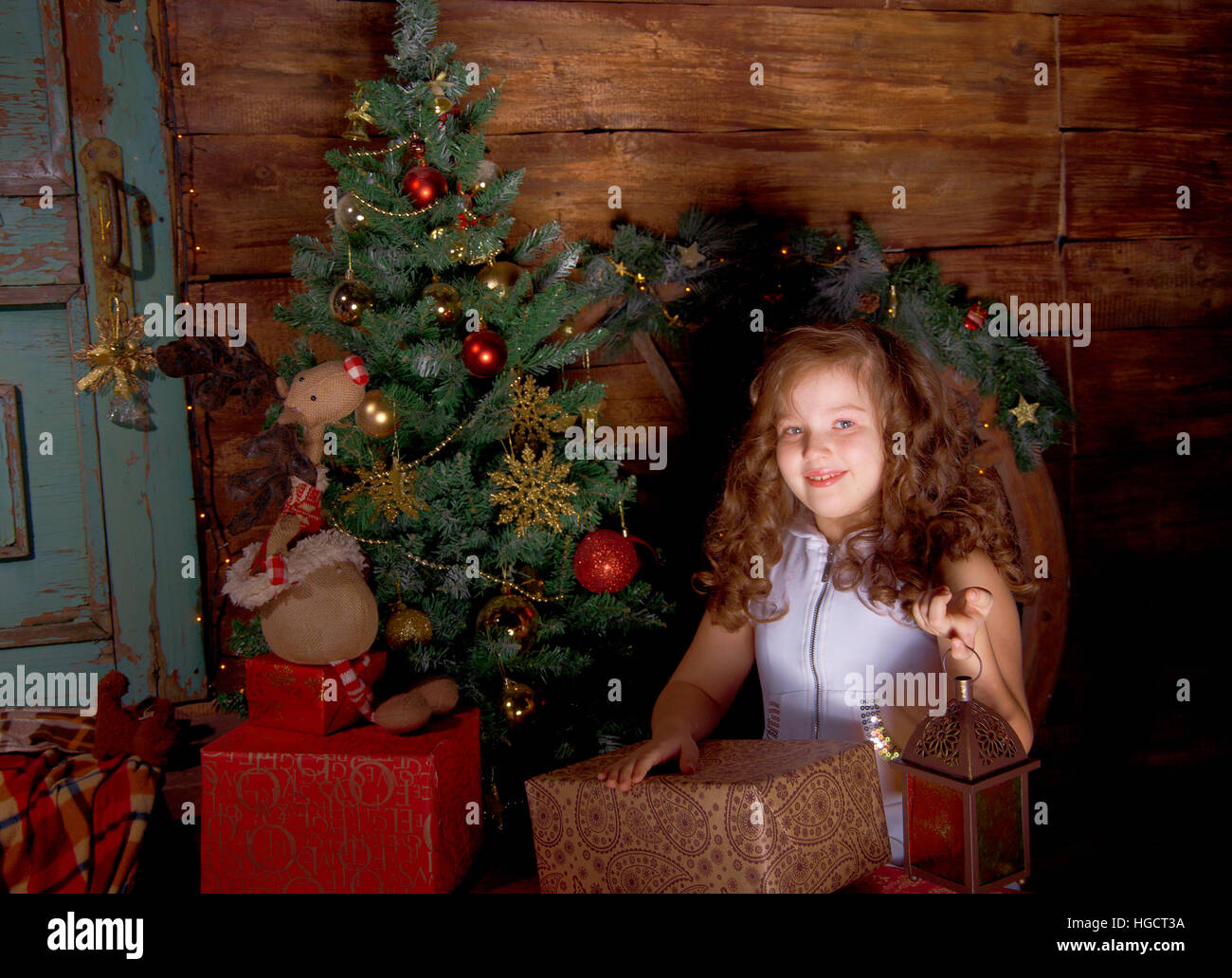 Glückliches kleine Mädchen schmücken Weihnachtsbaum im schönen Wohnzimmer mit traditionellen Kamin. Stockfoto