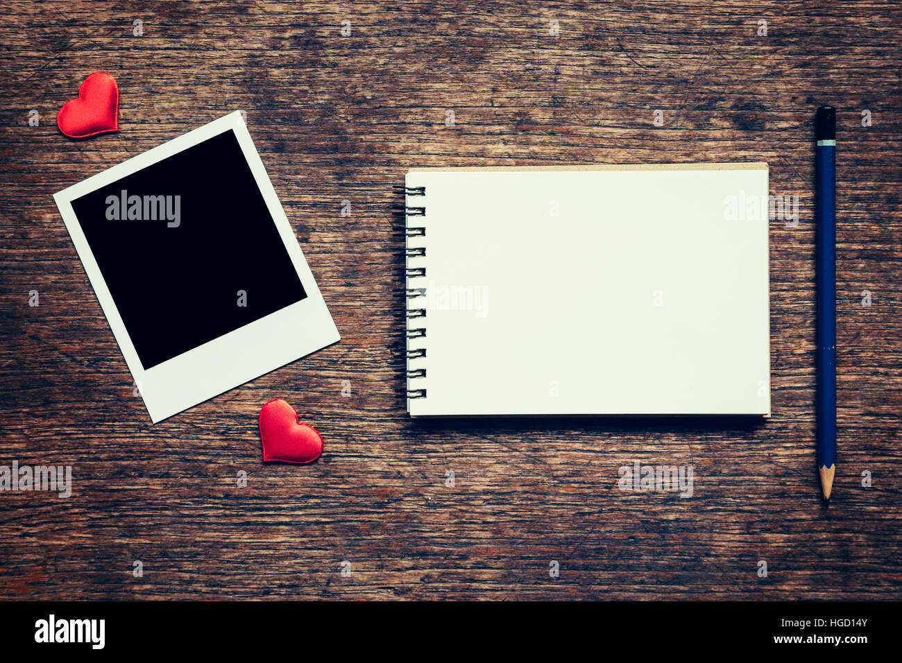 Leere Foto Frame, Notebook, Bleistift und roten Herz auf Holztisch Hintergrund. Stockfoto