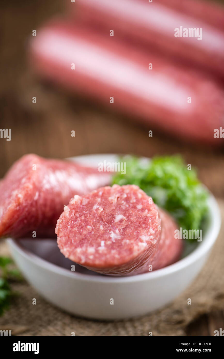 Deutsche Mettwurst (Tiefenschärfe; detaillierte Nahaufnahme) auf hölzernen Hintergrund Stockfoto
