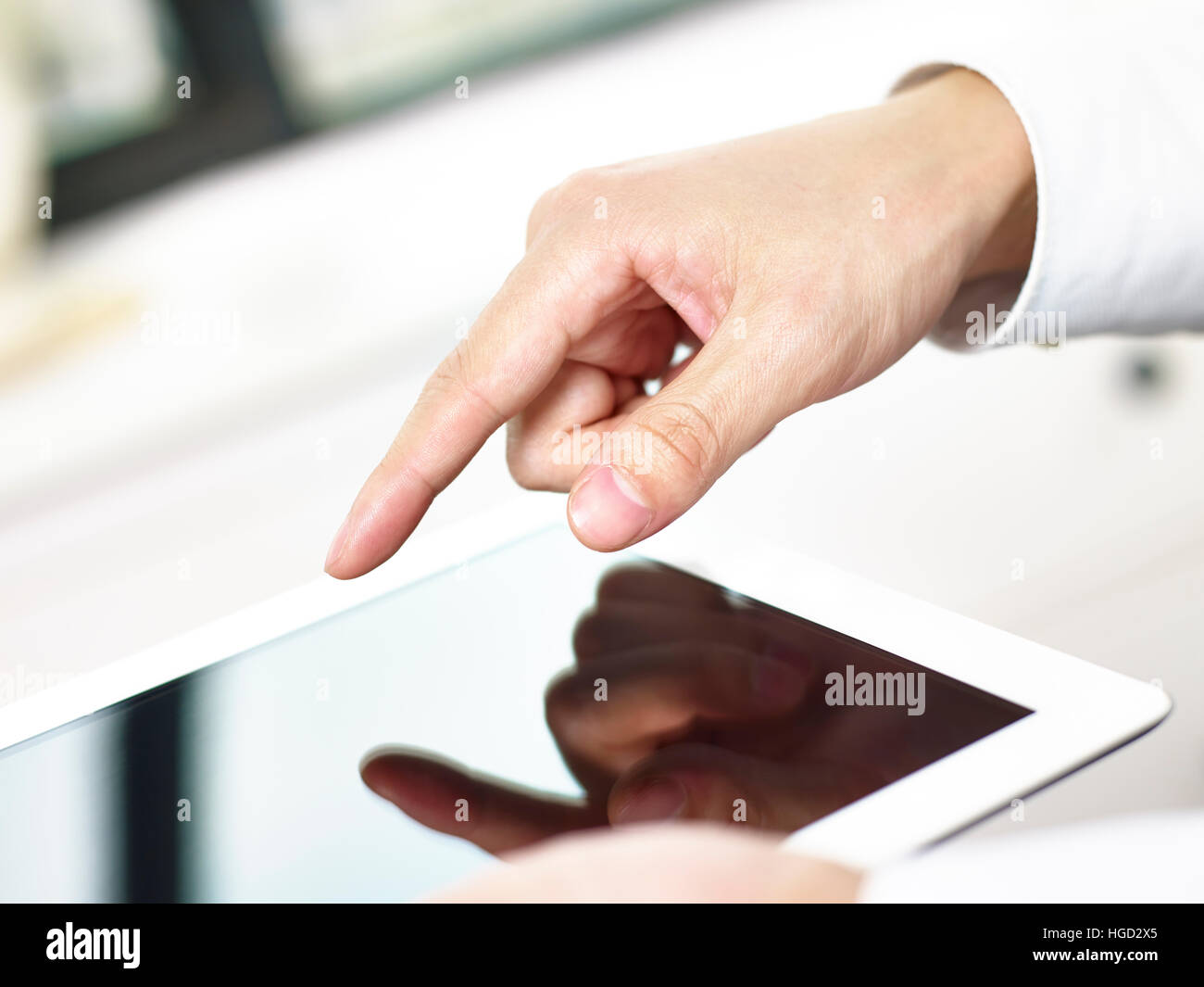 Nahaufnahme der Hände und Finger eines Geschäftsmannes Tippen auf den Bildschirm eines Tablet-Computers. Stockfoto