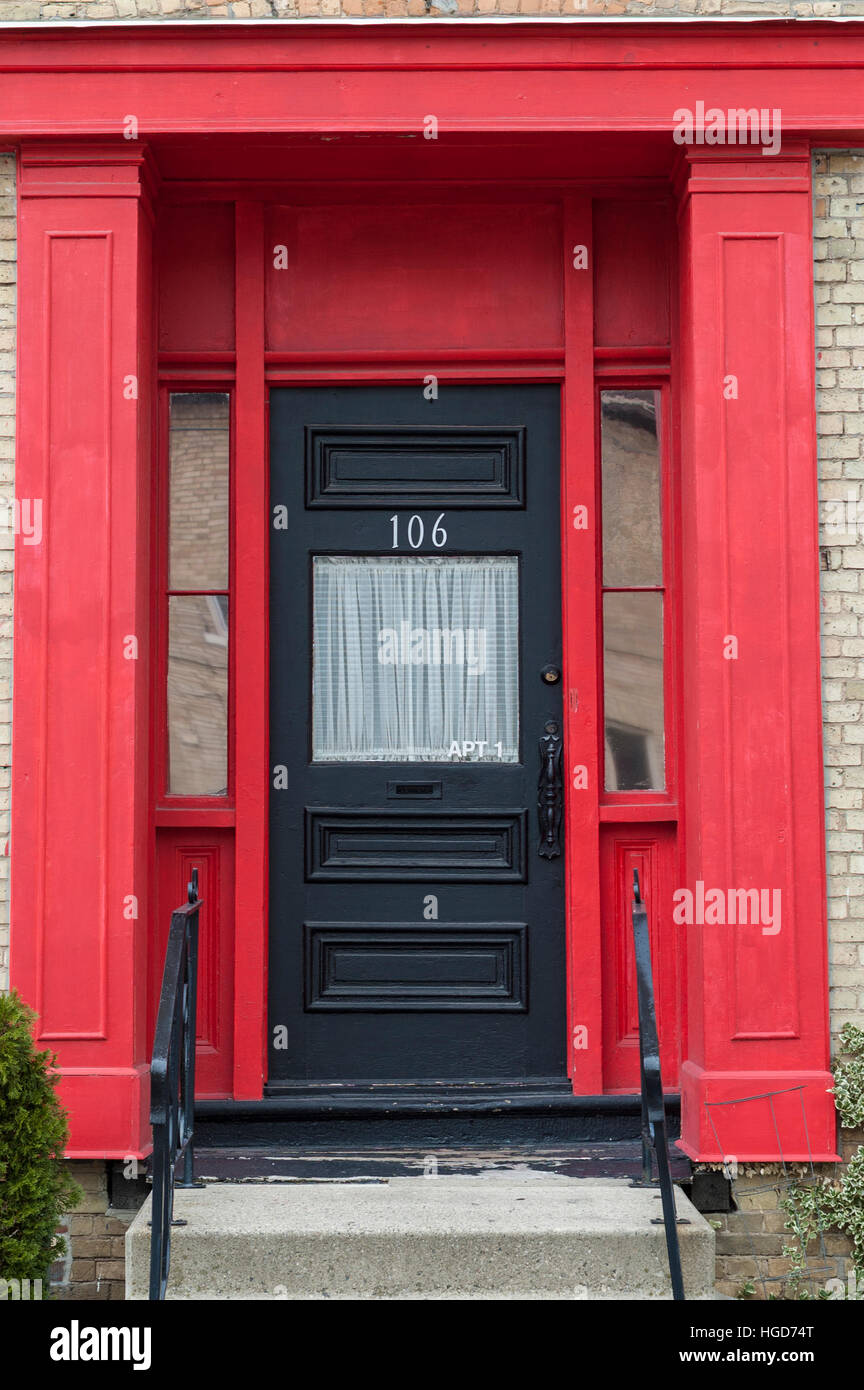Eine traditionelle Heimat schwarz Tür mit einem roten Rahmen in London, Ontario, Kanada. Stockfoto