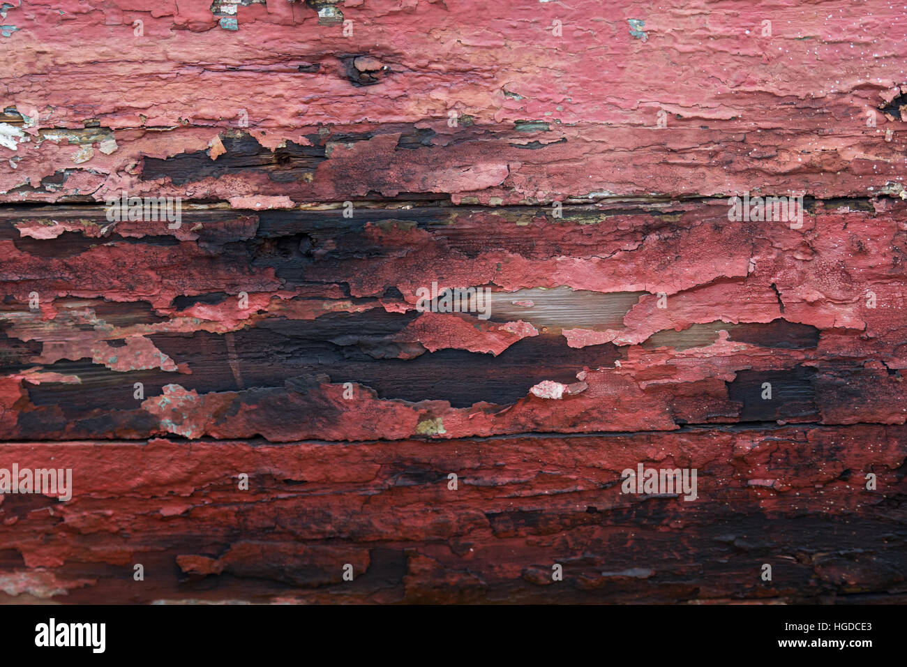 Abgeplatzte rote Farbe am alten Holz Hintergrund Stockfoto