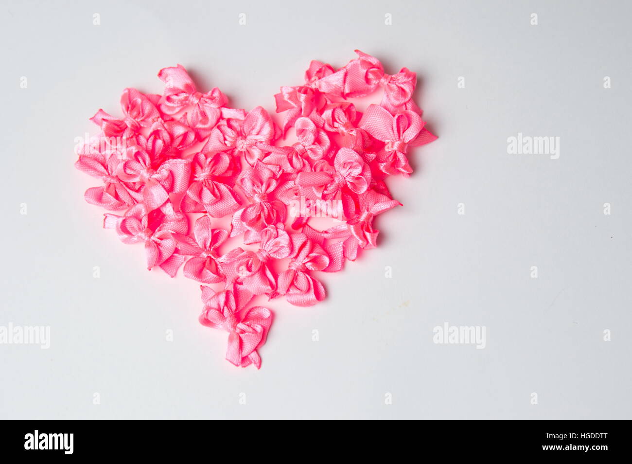 Herzform gemacht von rosa Bändern auf weiß Stockfoto