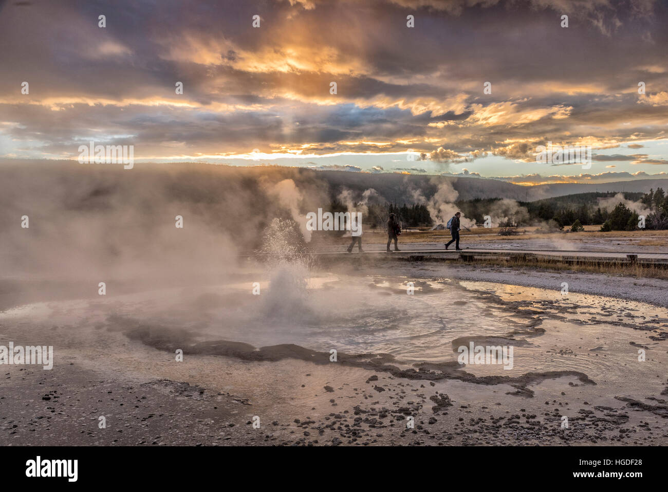 USA, Wyoming, Yellowstone, Nationalparks, UNESCO-Welterbe, Upper Geyser Basin, Menschen wandern bei Sonnenuntergang Stockfoto