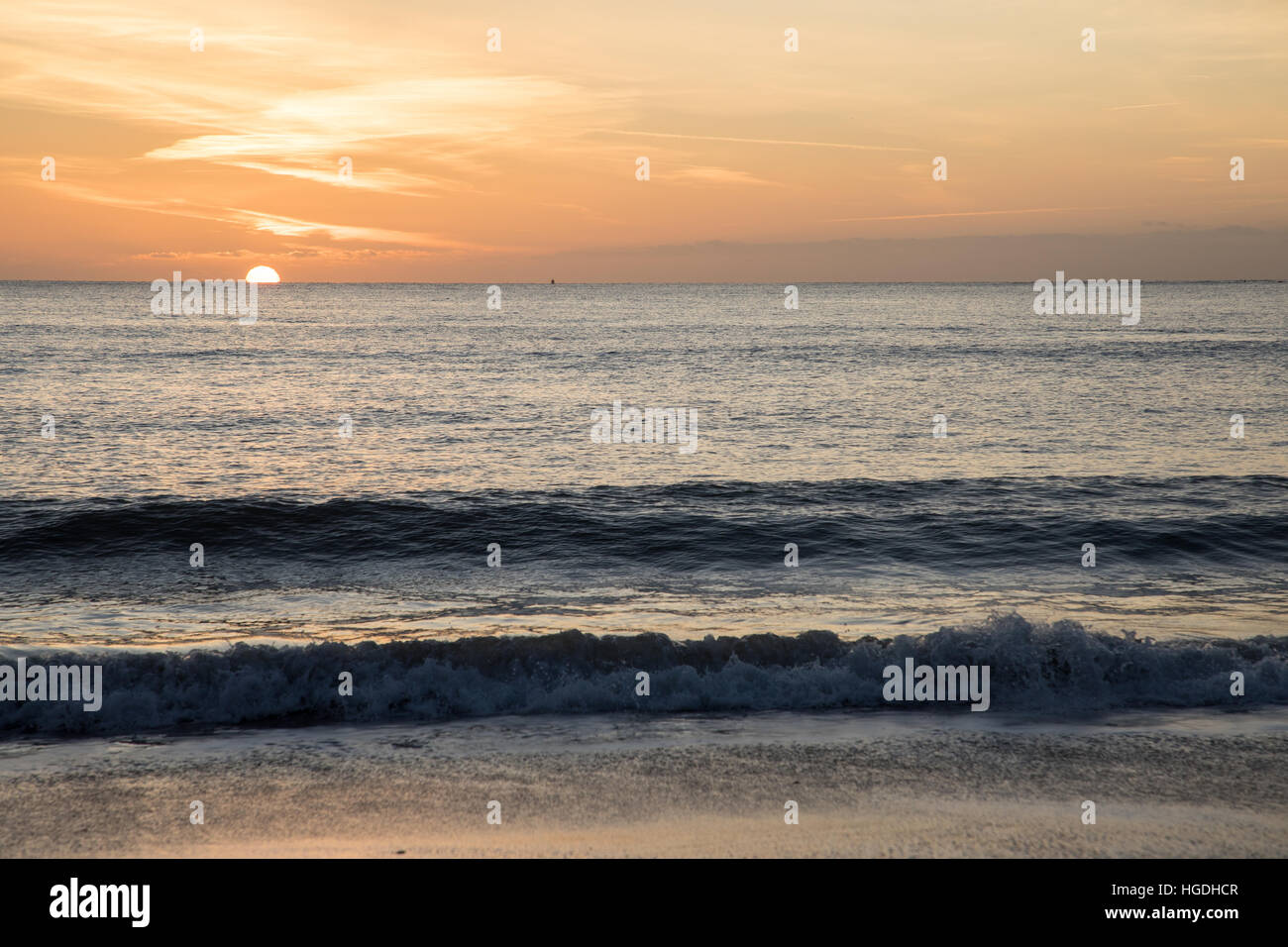 Sonne spähte über den Horizont bei Sonnenaufgang in einer Bucht Stockfoto