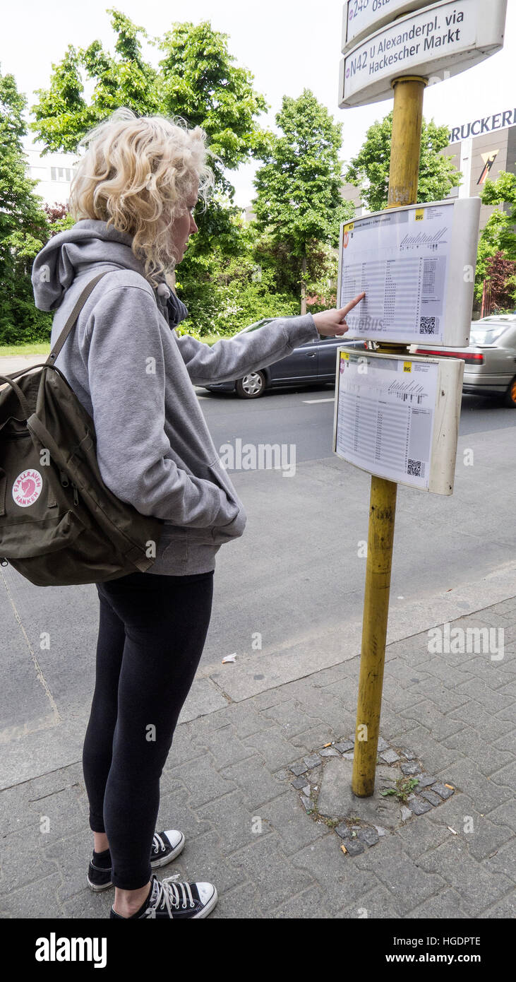 Backpacker prüft Zeitplan Bushaltestelle Berlin Deutschland Stockfoto