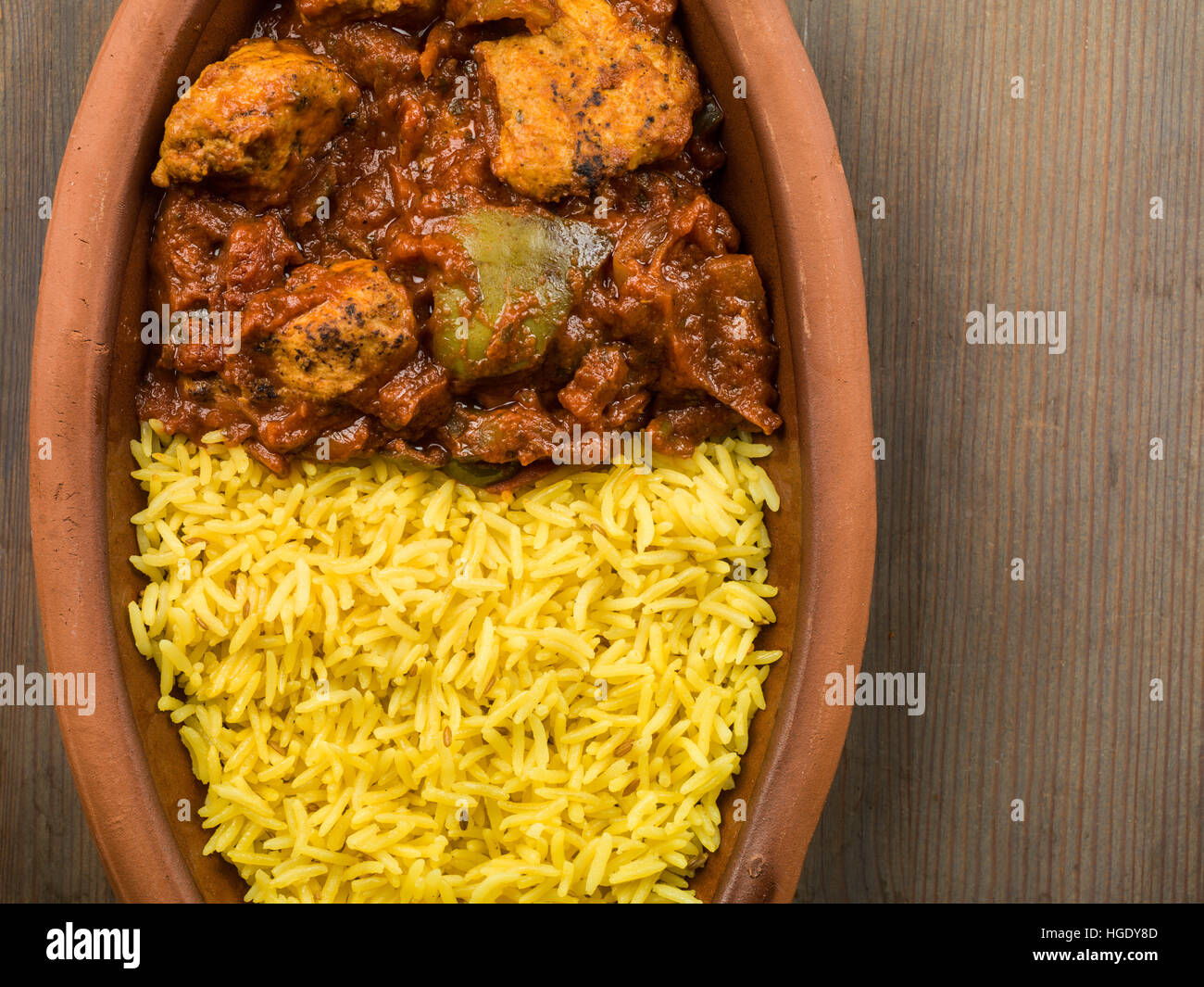 Frisch zubereitete Authentische indische Stil würzig Jalfrezi Huhn Curry serviert mit gelber Reis Pilaw Mahlzeit ohne Menschen und Flach Zusammensetzung Stockfoto