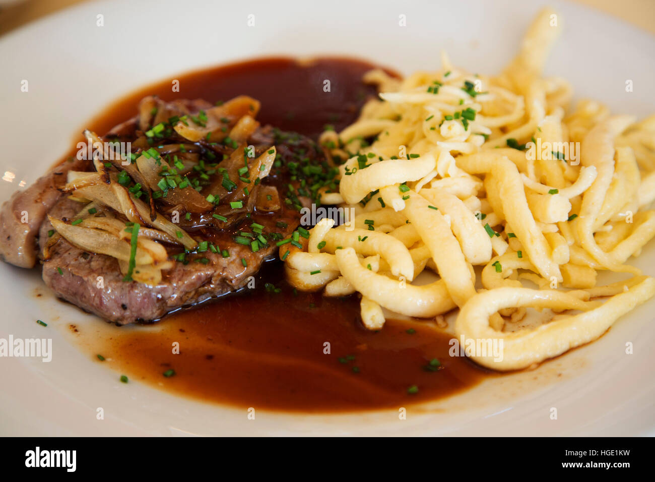 Ein Schweinesteak und Spätzle serviert am Stuttgarter Flughafen in Stuttgart, Deutschland. Das Essen ist typisch für die schwäbische Küche. Stockfoto