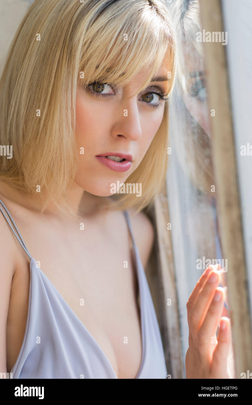 Ernste junge Frau am Fenster Stockfoto