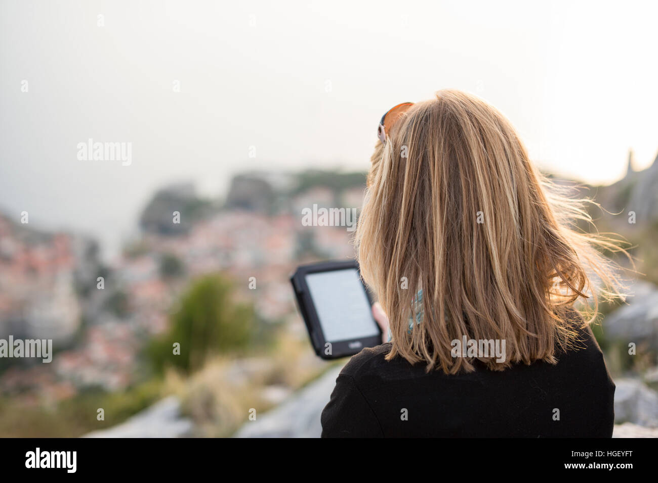 Rückansicht der Frau liest Buch über e-Reader, Dubrovnik, Kroatien Stockfoto