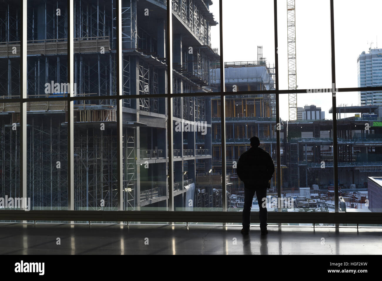Ein Mann ist wie er im Inneren Ort der Rogers Arena in Edmonton, Alberta, Kanada steht und auf Weiterbau schaut Silhouette Stockfoto