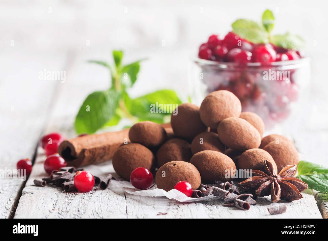 Hausgemachte gesunde vegane Schokolade Trüffel mit Cranberry auf Papier auf weißem Holz Hintergrund Stockfoto