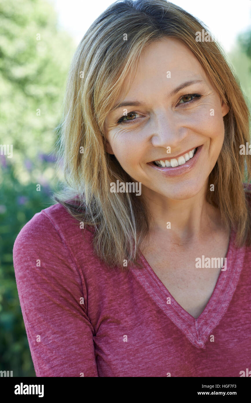 Im freien Kopf und Schultern Portrait Of Smiling Reife Frau Stockfoto
