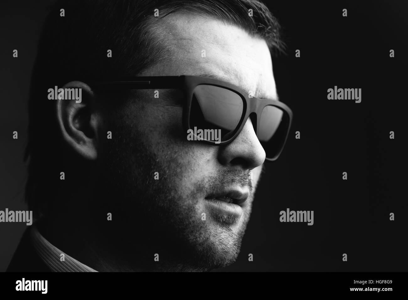Mann mit Sonnenbrille in einem dunklen Raum Stockfoto