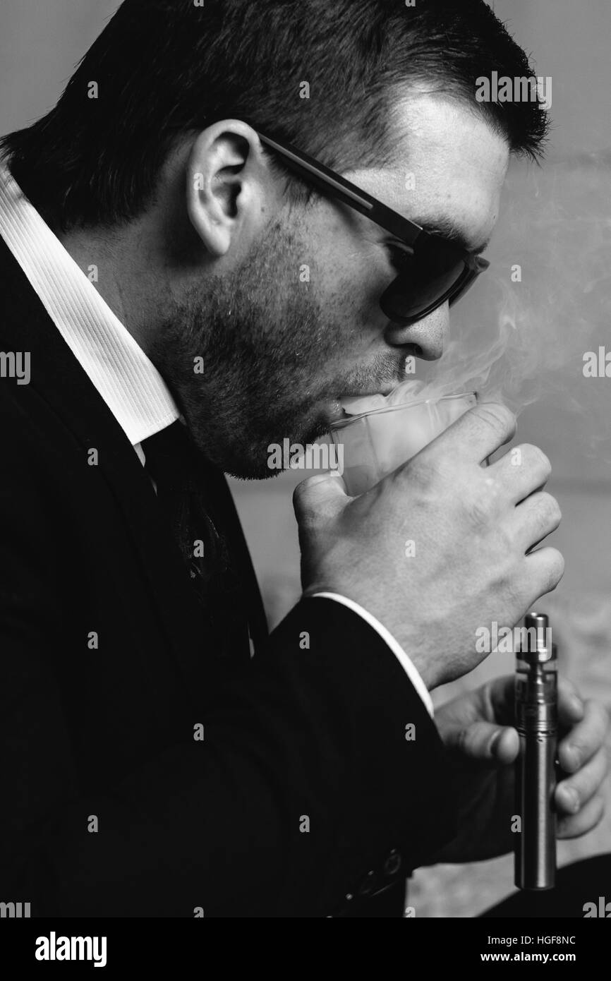 Mann mit einem Glas Whiskey und elektronische Zigarette Stockfoto