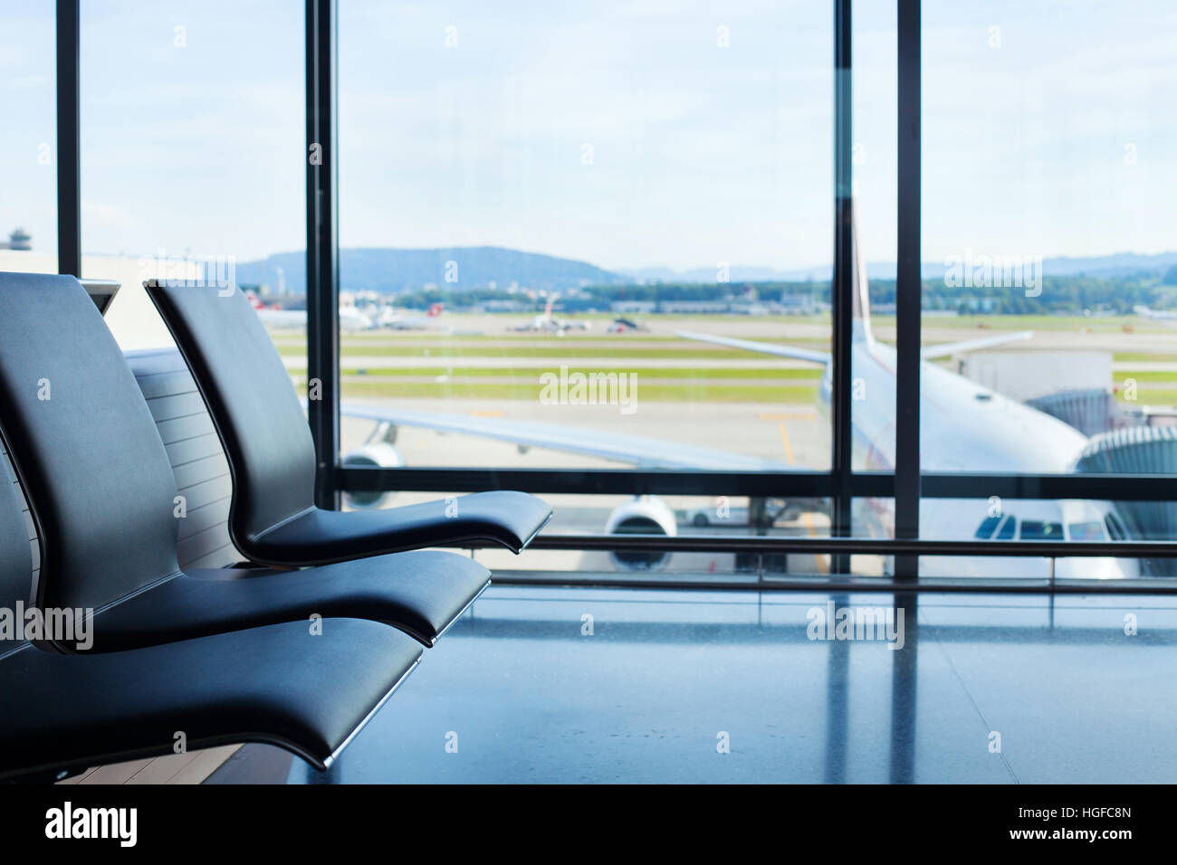 Flughafen-Hintergrund, Stühle im Warteraum und Flugzeug im Fenster, Interieur Stockfoto