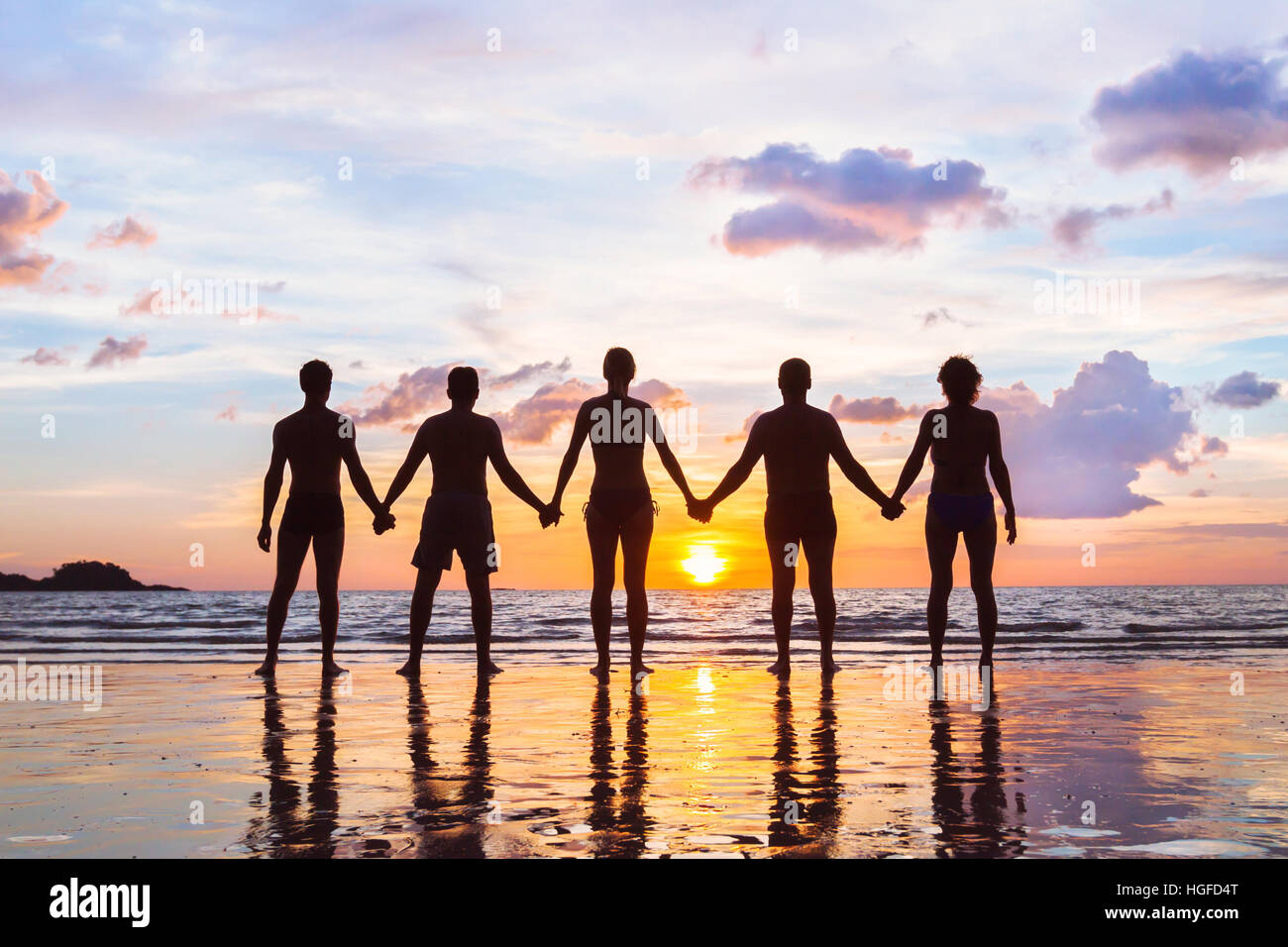 Gemeinschaft oder Gruppe Konzept, Silhouetten von Menschen zusammenstehen und Hand in Hand, Team am Strand, Einheit Hintergrund Stockfoto