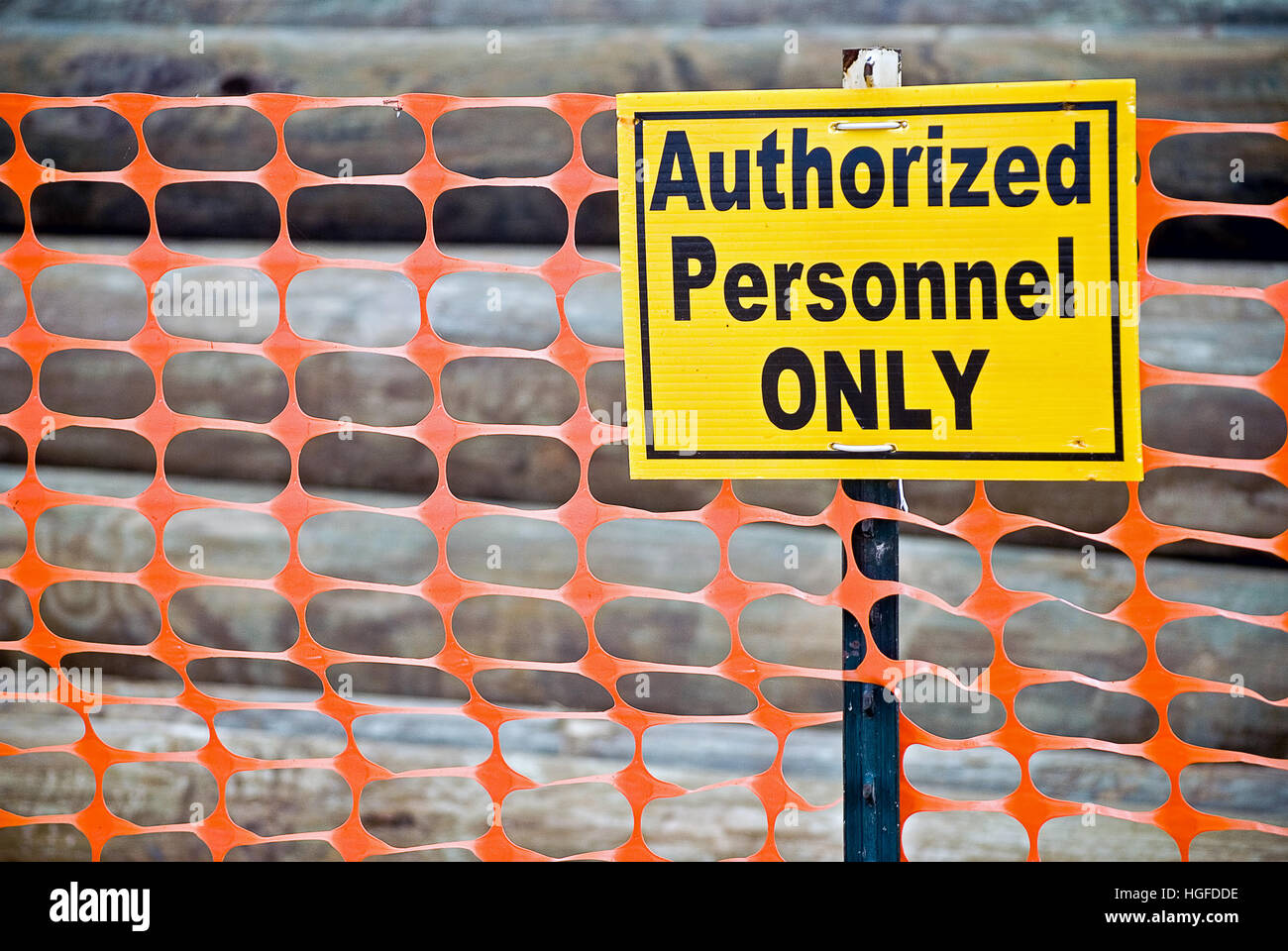 fetten gelben Warnschild am orange Zaun Stockfoto