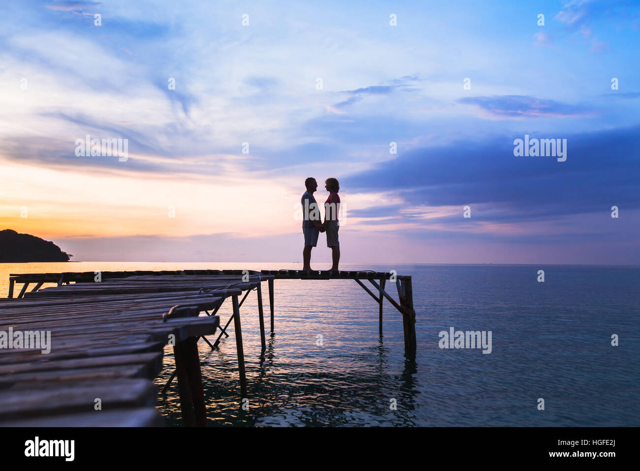 schöne romantische Liebe Hintergrund, Silhouette der liebevollen paar auf dem Pier am sunset beach Stockfoto
