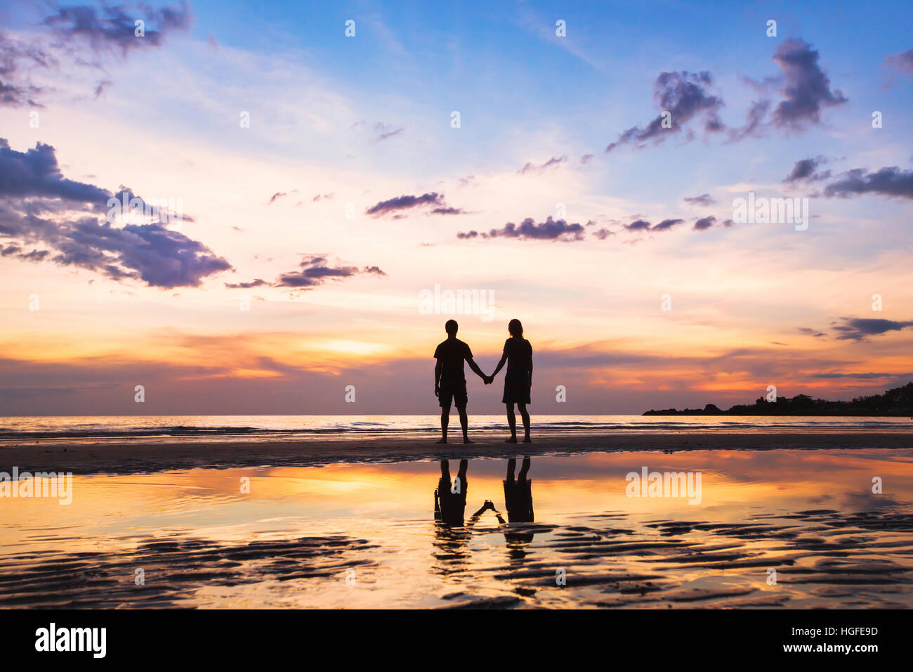 glückliche Familie am Strand, Silhouette des Paares bei Sonnenuntergang, Mann und Frau, Beziehung, Liebe Stockfoto