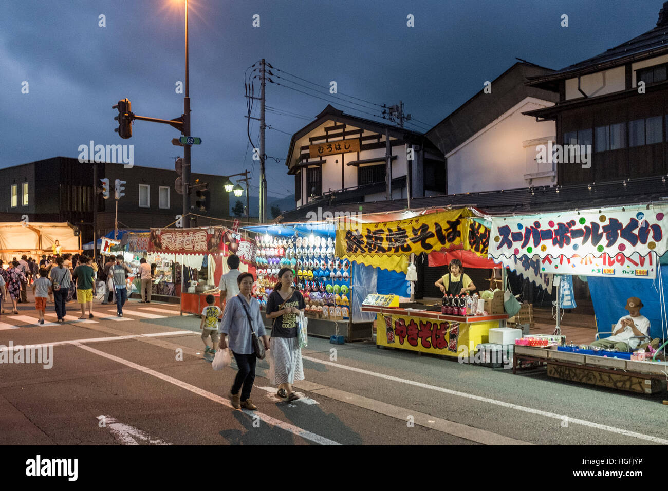 Die Menschen gehen vorbei an Ständen auf Bokushi Straße während einer Sommerfestivals in Shiozawa, Japan. Stockfoto