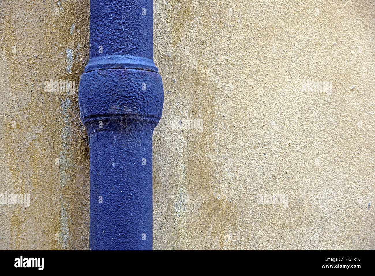 Blaue Regenwasser Rohr hergestellt aus Zinn auf Haus Ecke dekorativen Steinen. Stockfoto