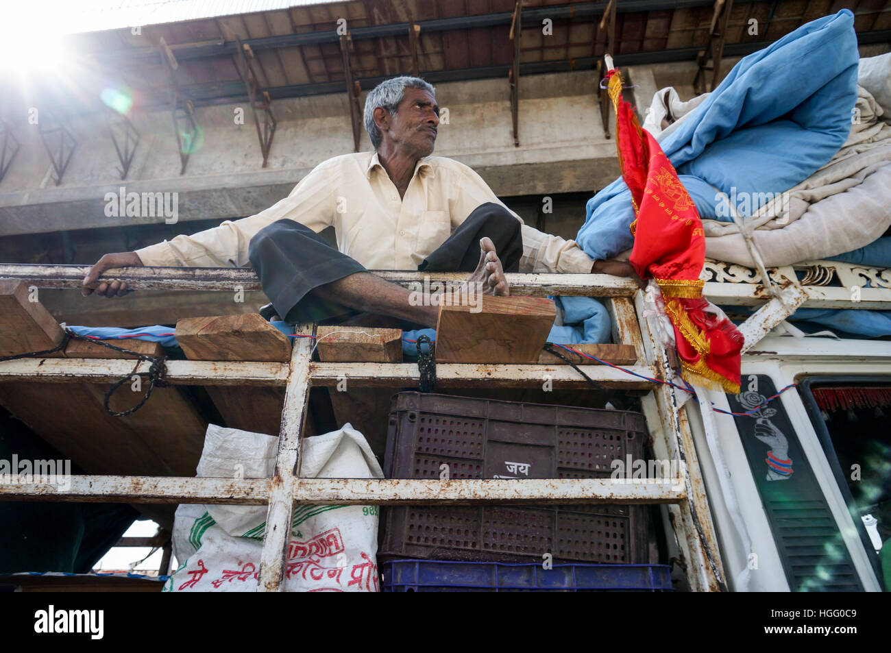 Indischer Mann sitzt auf dem Dach des LKW, Indien Stockfoto