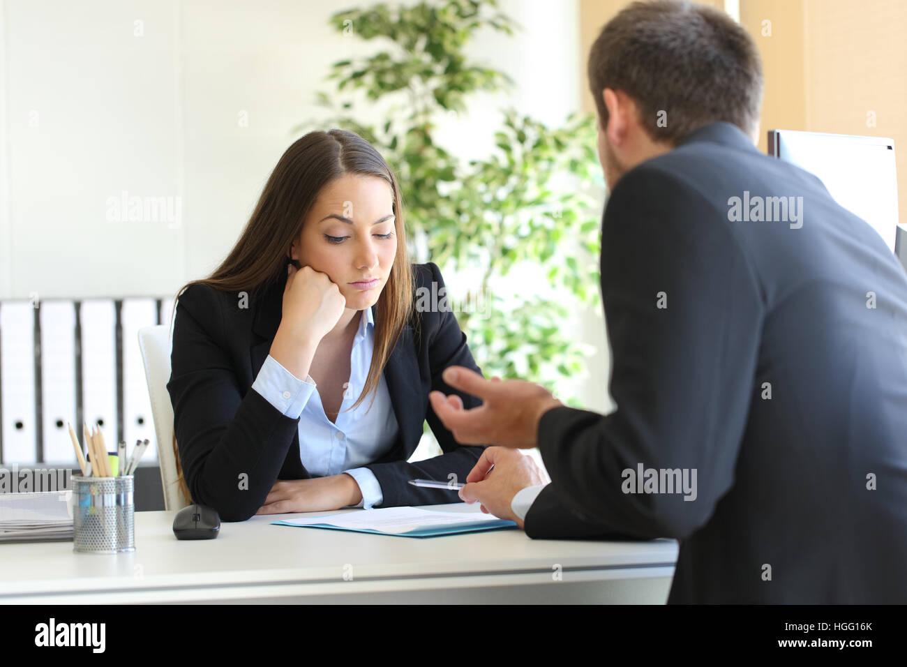Schlechte Verkäufer versuchen, an einen gelangweilten Client in ihrem Büro oder Geschäftsmann in einem Vorstellungsgespräch zu überzeugen Stockfoto